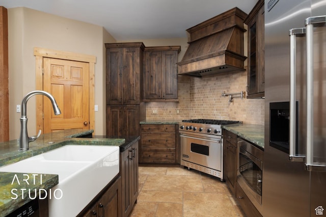 7352 Pine Dr, Park City, UT 84098 - kitchen with backsplash, premium range hood, sink, built in appliances, and dark stone countertops