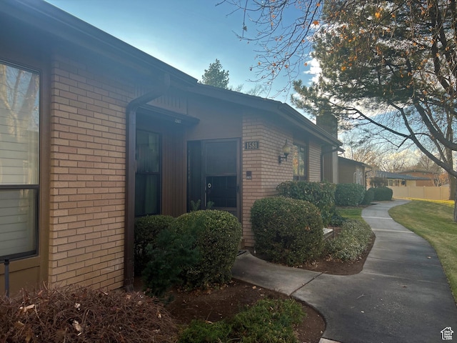 1581 E 6470 S, Murray, UT 84121 - view of side of home featuring brick siding and a chimney