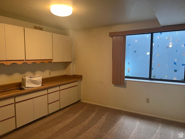 1581 E 6470 S, Murray, UT 84121 - kitchen with dark colored carpet, white cabinetry, and baseboards