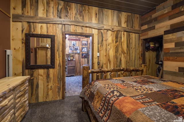 carpeted bedroom featuring wooden walls