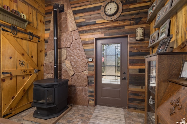 entryway featuring a wood stove and wooden walls