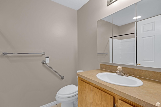 bathroom with vanity, toilet, and a shower