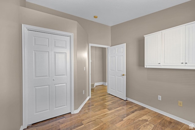unfurnished bedroom with light hardwood / wood-style floors and a closet