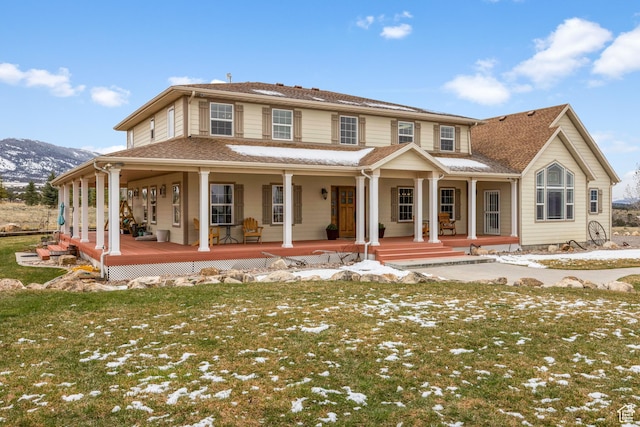 view of front of house featuring covered porch, a mountain view, and a yard