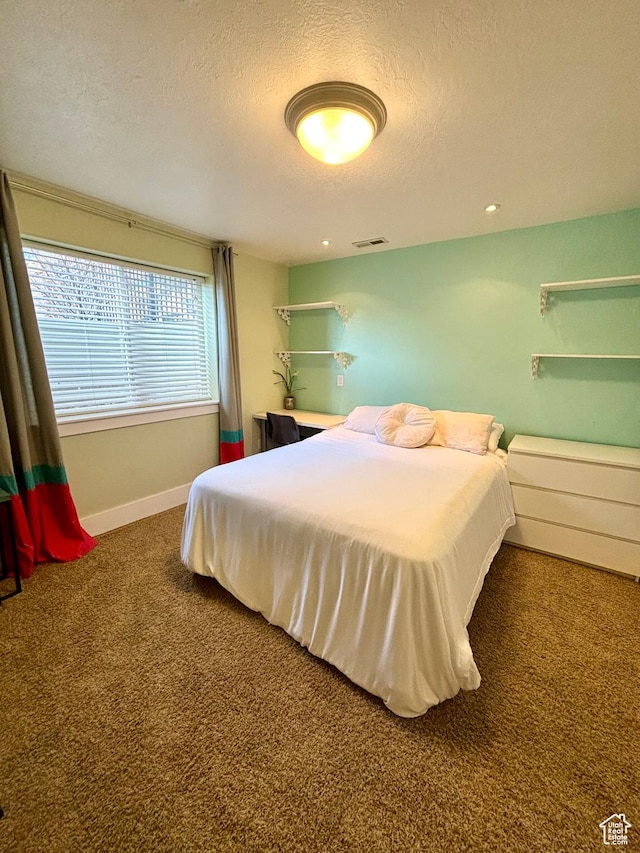 carpeted bedroom with a textured ceiling and baseboards