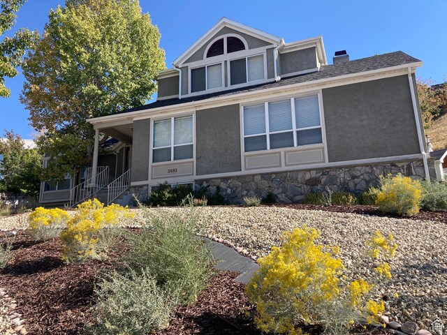 3893 S Bountiful Blvd, Bountiful, UT 84010 - farmhouse inspired home featuring a chimney, stucco siding, covered porch, and stone siding