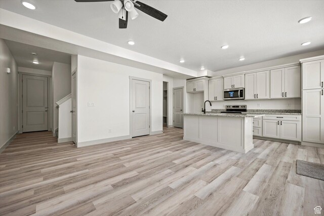 639 S 85 E Unit 28, Smithfield, UT 84335 - kitchen featuring light stone counters, stainless steel appliances, light wood-type flooring, and a sink