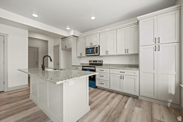 639 S 85 E Unit 28, Smithfield, UT 84335 - kitchen featuring light wood-style flooring, an island with sink, appliances with stainless steel finishes, and a sink