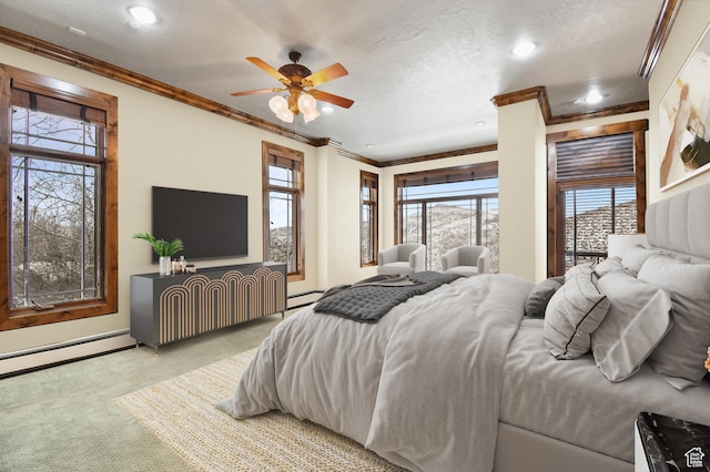 bedroom featuring ceiling fan, carpet floors, ornamental molding, and a baseboard heating unit