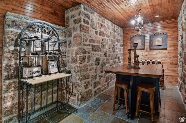 wine room with wood walls, wood ceiling, and a notable chandelier