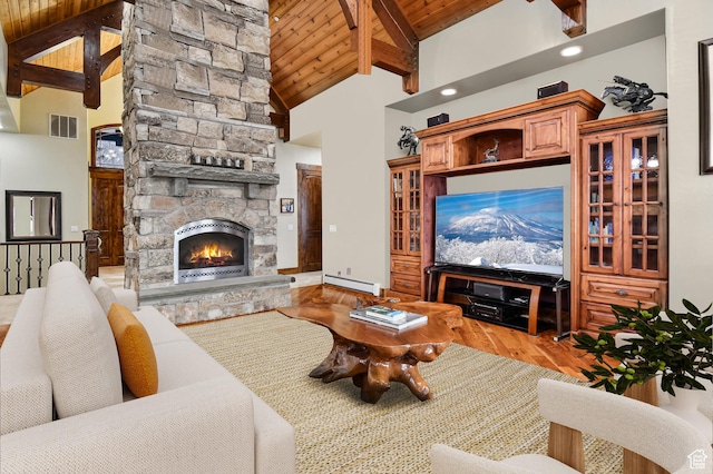 living room with a baseboard heating unit, hardwood / wood-style flooring, high vaulted ceiling, beamed ceiling, and a fireplace