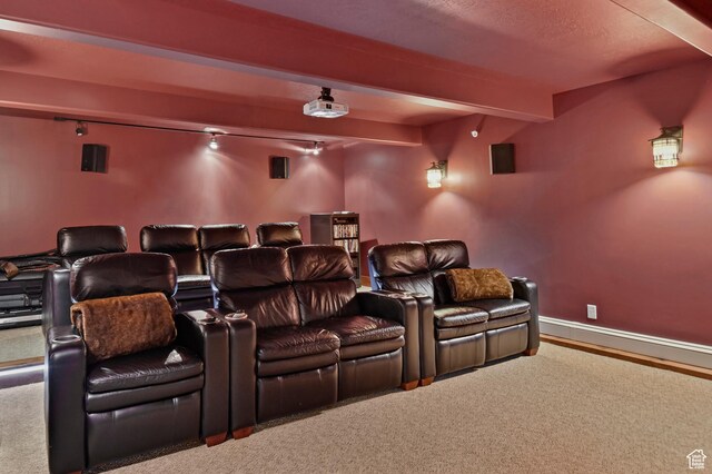 home theater room featuring beam ceiling and carpet floors
