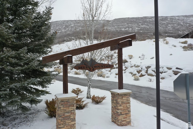 snow covered deck with a mountain view
