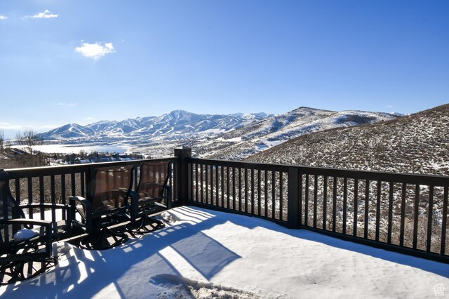 snow covered deck with a mountain view