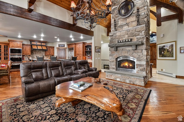 living room featuring high vaulted ceiling, light wood-type flooring, a fireplace, a baseboard radiator, and beamed ceiling