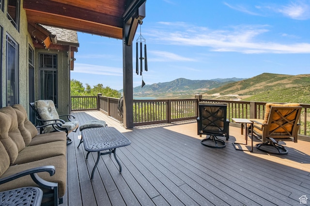 wooden terrace featuring a mountain view and an outdoor hangout area