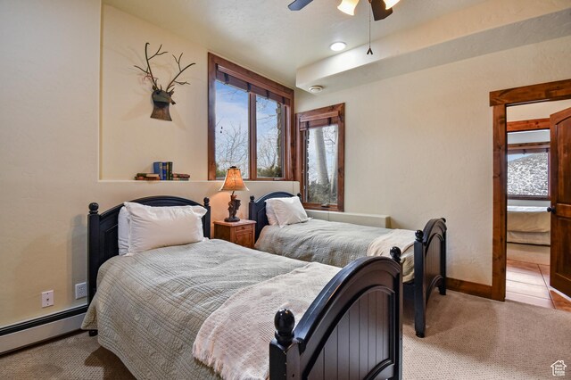 carpeted bedroom featuring ceiling fan and a baseboard radiator