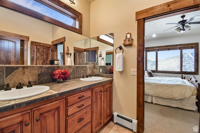 bathroom with a mountain view, vanity, backsplash, ceiling fan, and a baseboard radiator