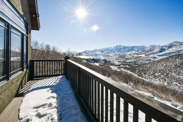snow covered back of property featuring a mountain view