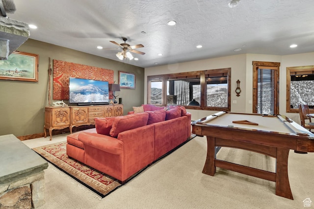 carpeted living room with ceiling fan, a textured ceiling, and billiards