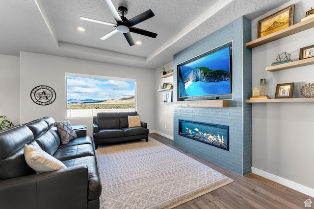 2217 E Emerald Ave, Eagle Mountain, UT 84005 - living area with wood finished floors, baseboards, a fireplace, ceiling fan, and recessed lighting