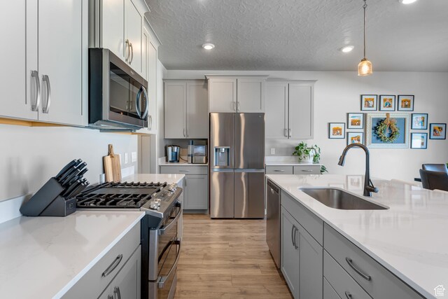 2217 E Emerald Ave, Eagle Mountain, UT 84005 - kitchen featuring appliances with stainless steel finishes, a sink, gray cabinets, a textured ceiling, and recessed lighting