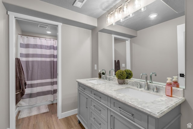 2217 E Emerald Ave, Eagle Mountain, UT 84005 - bathroom with wood finished floors, double vanity, curtained shower, and baseboards