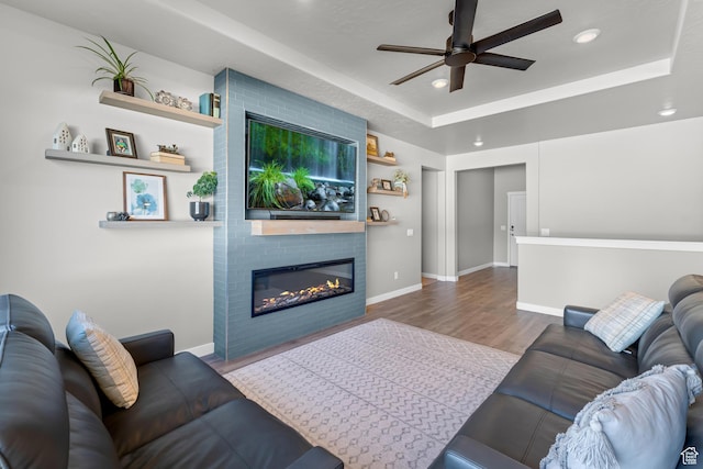 2217 E Emerald Ave, Eagle Mountain, UT 84005 - living room featuring a ceiling fan, a fireplace, a raised ceiling, wood finished floors, and recessed lighting