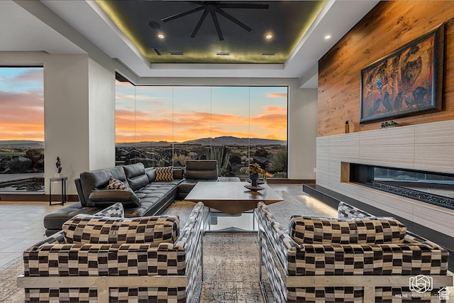 2523 N Chaco Trl, St George, UT 84770 - living area with wood walls, a tray ceiling, a ceiling fan, a tiled fireplace, and recessed lighting