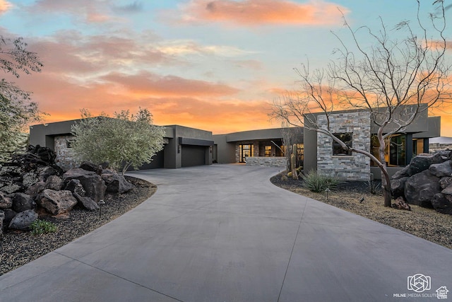 2523 N Chaco Trl, St George, UT 84770 - contemporary home featuring stucco siding, stone siding, curved driveway, and a garage