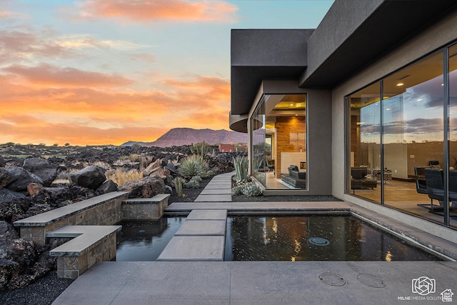 2523 N Chaco Trl, St George, UT 84770 - patio terrace at dusk featuring a mountain view and an outdoor pool