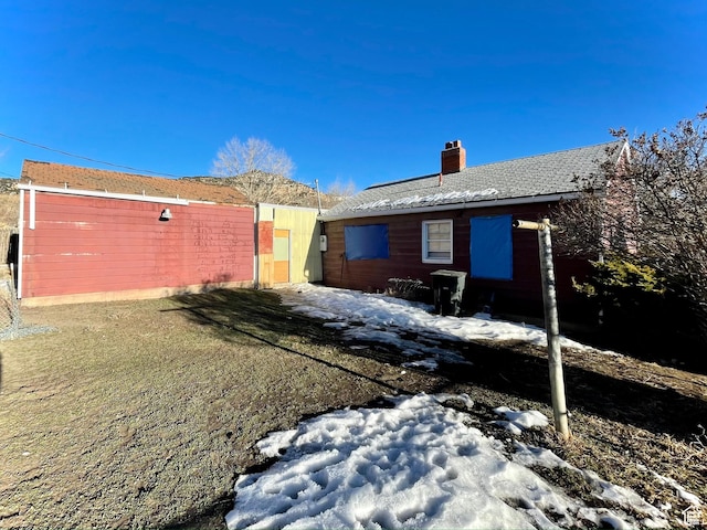 view of snow covered back of property