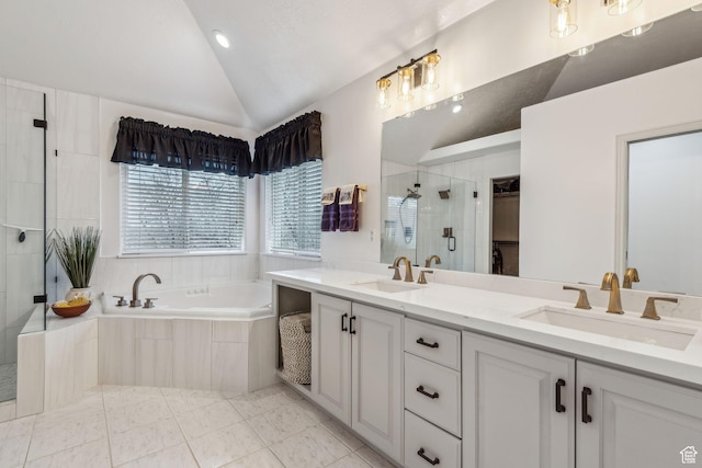 bathroom with independent shower and bath, tile patterned flooring, vaulted ceiling, and vanity