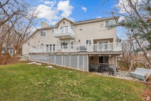 back of house featuring a balcony, a patio, a deck, and a yard