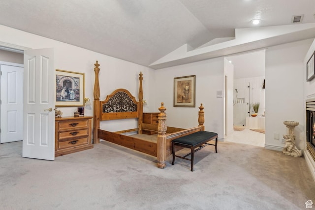 carpeted bedroom featuring ensuite bathroom and vaulted ceiling