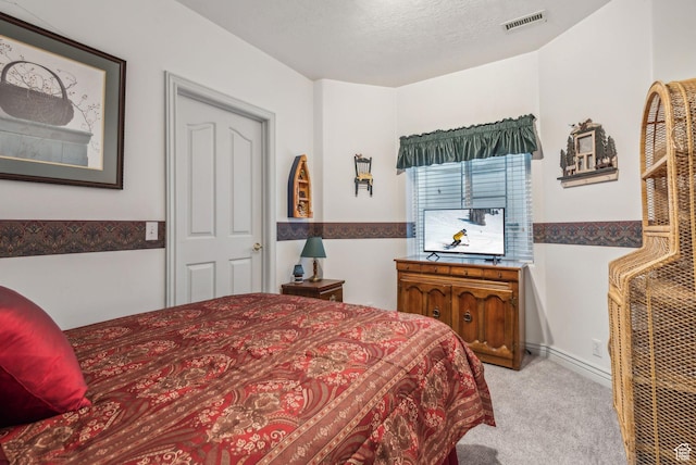 bedroom featuring a textured ceiling and light carpet