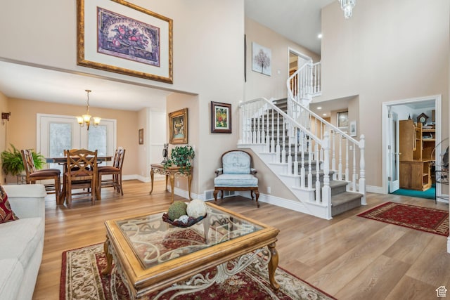 living room featuring a towering ceiling, hardwood / wood-style floors, and a chandelier