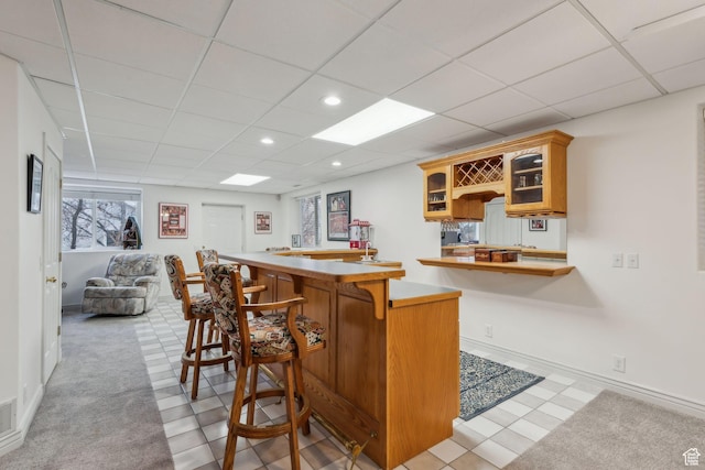 interior space featuring a paneled ceiling and light carpet