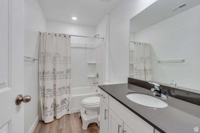 full bathroom with vanity, toilet, wood-type flooring, and shower / tub combo