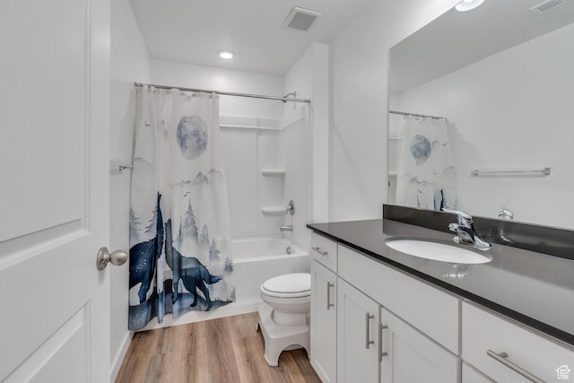full bathroom featuring hardwood / wood-style flooring, shower / bath combo, toilet, and vanity