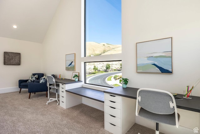 office featuring a mountain view, light colored carpet, and high vaulted ceiling