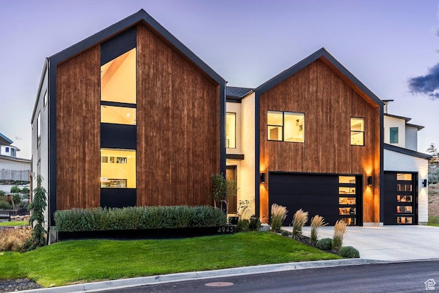 contemporary house featuring a yard and a garage
