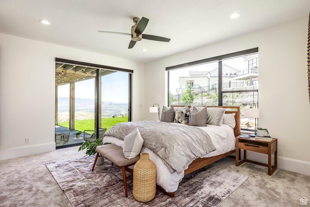 carpeted bedroom with a mountain view, access to outside, and ceiling fan