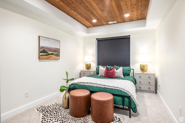 carpeted bedroom featuring a raised ceiling and wooden ceiling