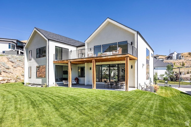 rear view of house featuring a yard, a patio, a balcony, and cooling unit