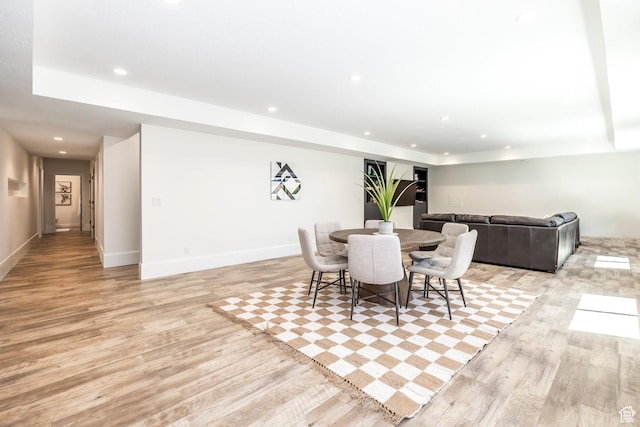 dining room featuring light hardwood / wood-style floors and a tray ceiling