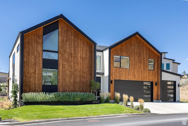 contemporary house featuring a garage and a front lawn