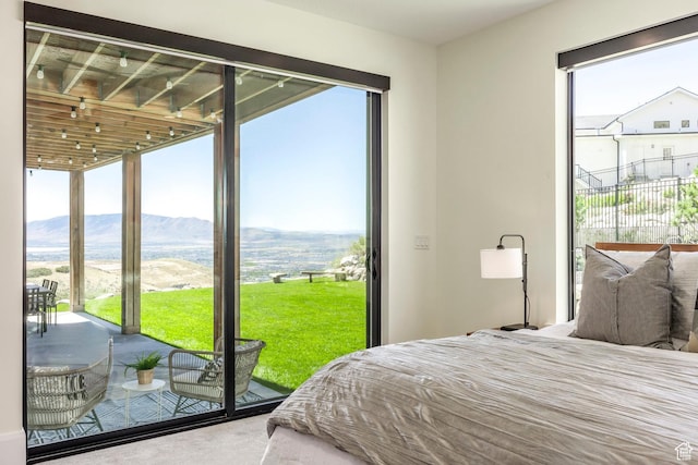 bedroom featuring a mountain view, carpet, and access to outside