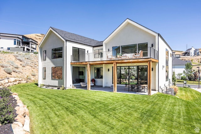 back of house featuring a yard, a balcony, cooling unit, and a patio area