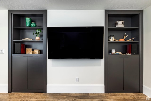 living room with built in shelves and a textured ceiling
